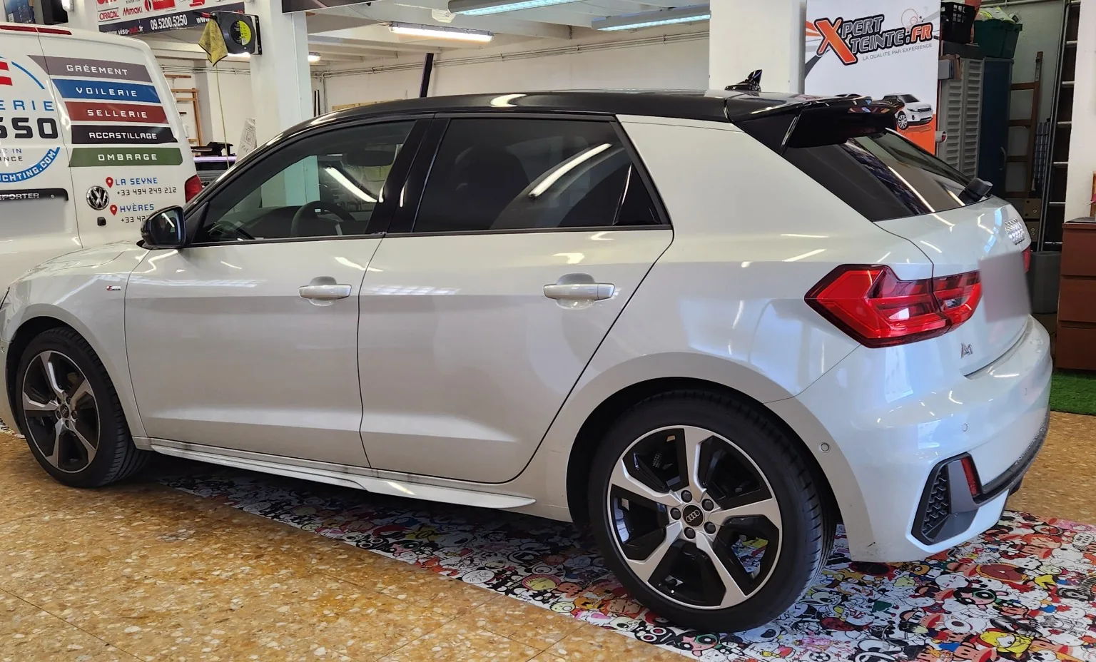 Audi A1 Sportback – vitres teintées 30 % et 95 % Audi A1 Sportback blanche au toit noir, avec vitres avant à 30 % et arrière à 95 %, vue de trois-quarts arrière.