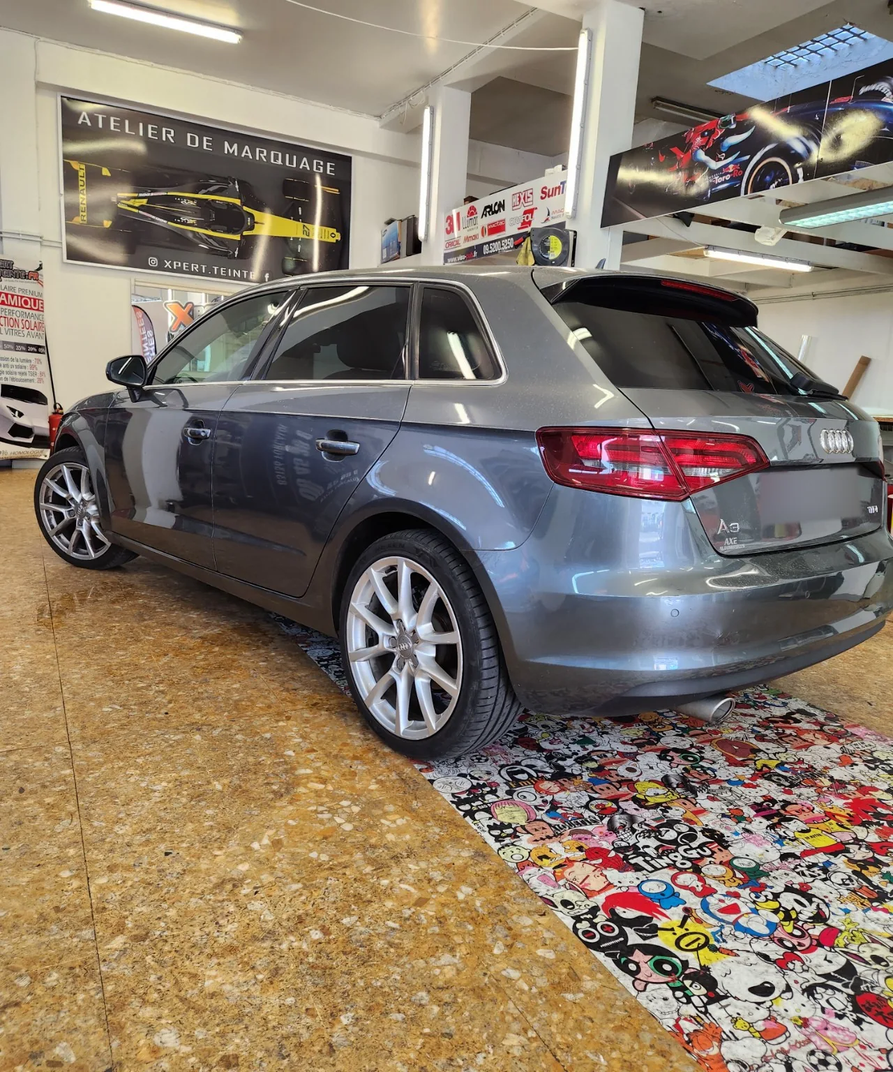 Audi A3 Sportback – arrière teinté à 95 % Audi A3 Sportback grise vue de trois-quarts arrière avec sa lunette et ses vitres arrière teintées à 95 %.