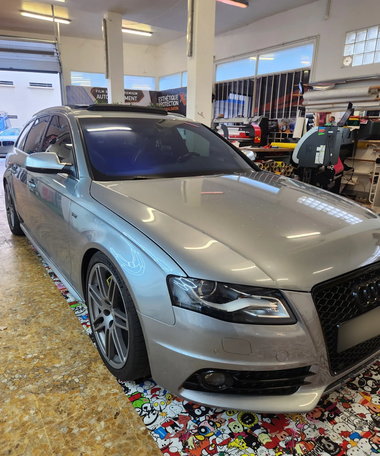 Audi A4 Avant B8 – pare-brise Iridium bleu à Toulon Audi A4 Avant B8 gris argent vue de trois-quarts avant à l’atelier de Toulon, avec les reflets bleus du pare-brise Iridium.