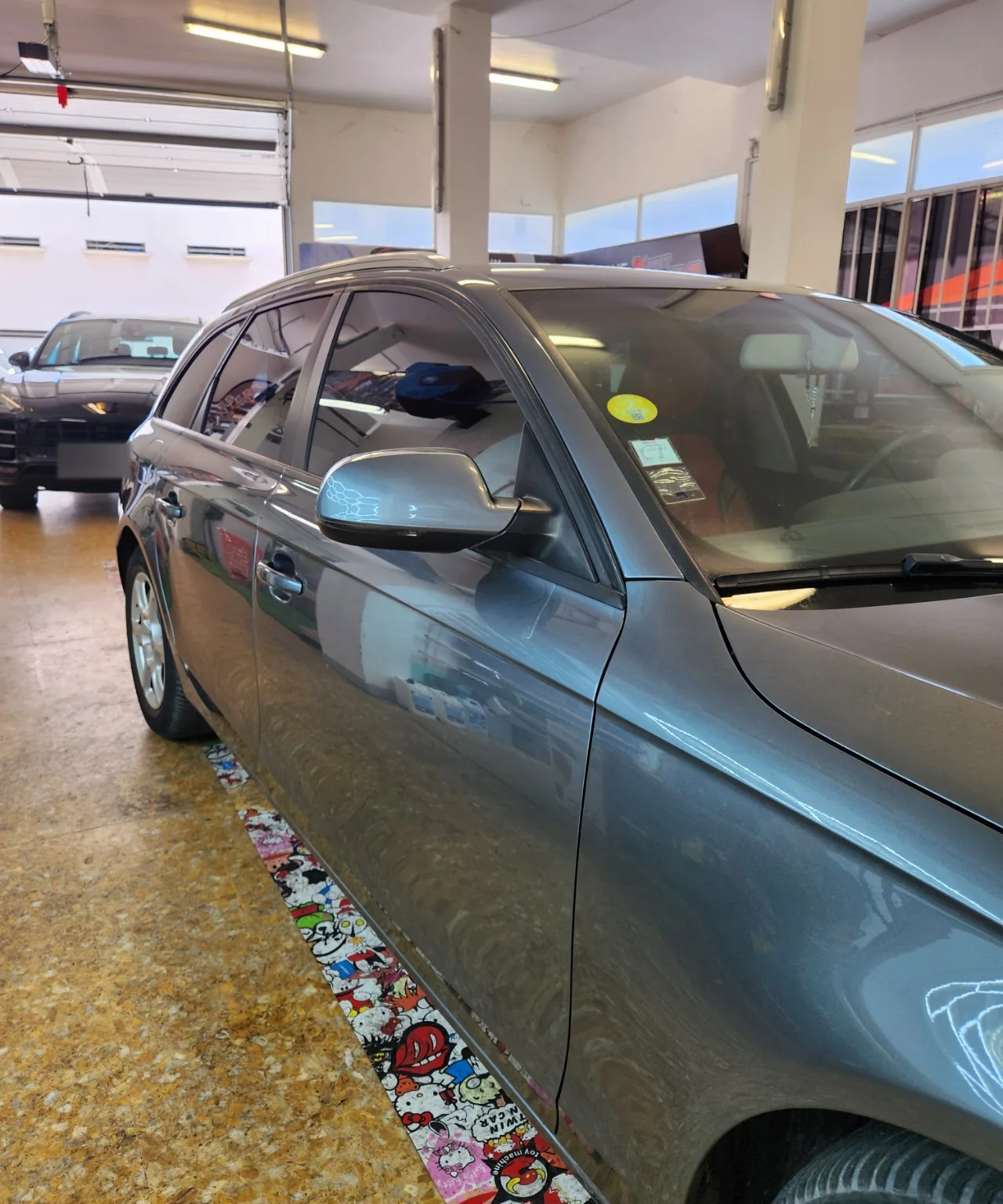 Audi A4 Avant – détail de la vitre avant Détail de la vitre avant et du rétroviseur de l’Audi A4 Avant grise.