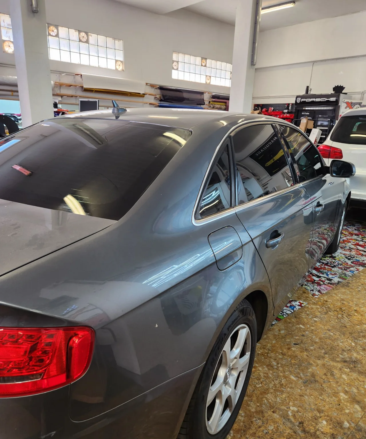 Audi A4 berline B8 – vitres avant 50 % et arrière 80 % Vue arrière droite de l’Audi A4 berline B8 grise montrant la lunette et les vitrages latéraux teintés à l’atelier Xpert Teinte.