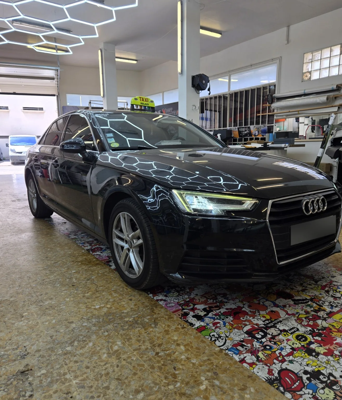 Vitres teintées Audi A4 taxi à Toulon – vue avant Audi A4 noire avec enseigne de taxi jaune, vue de trois quarts avant après la pose de films teintés chez Xpert Teinte à Toulon.