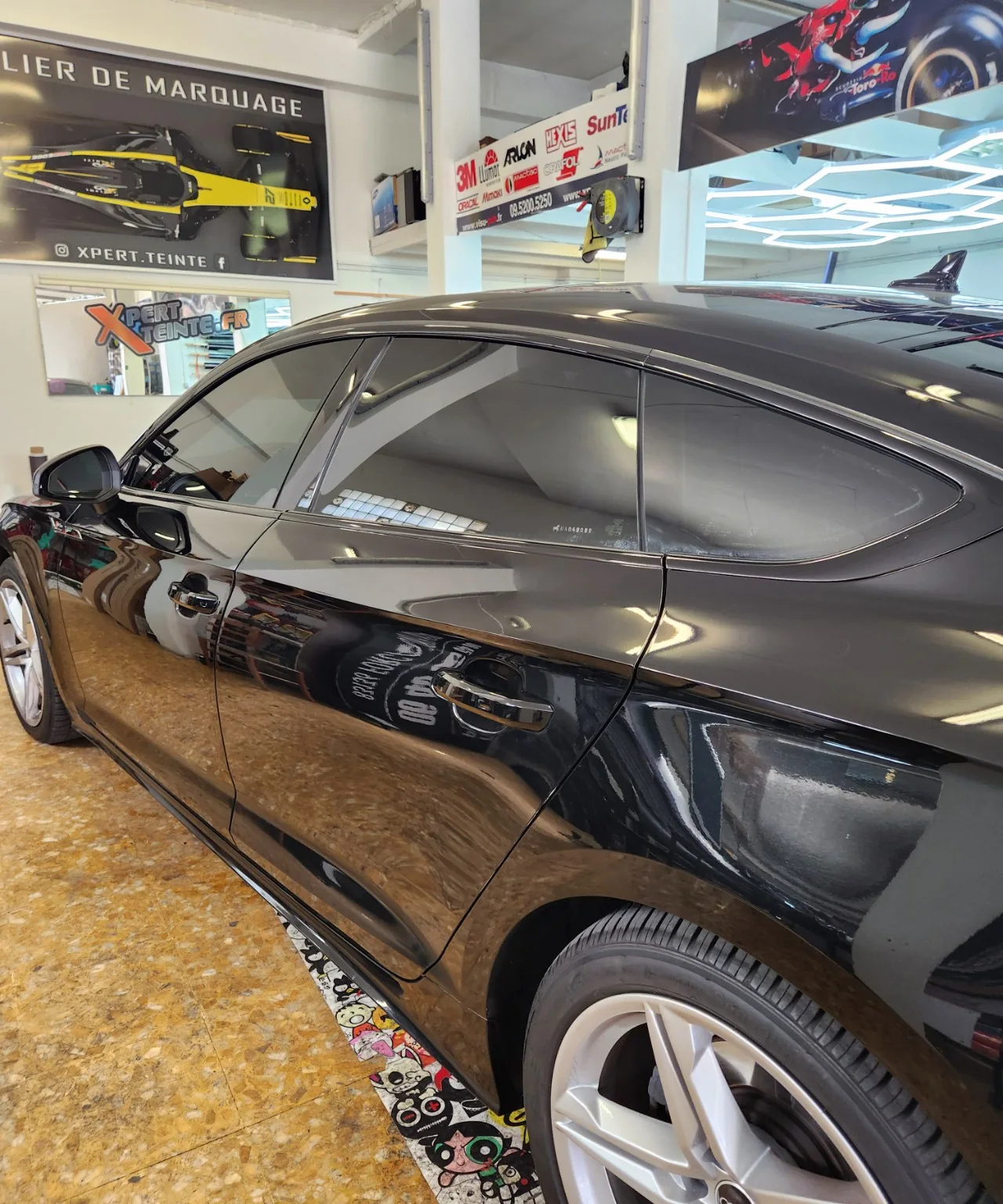 Audi A5 Sportback – détail des vitres teintées 50 % / 95 % Vitres latérales et custode de l’Audi A5 Sportback noire, avec une teinte à 50 % devant et 95 % derrière.