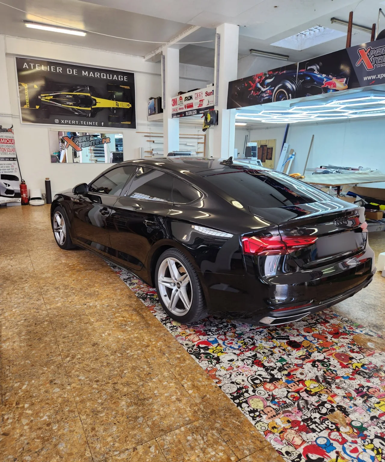 Audi A5 Sportback noire – vue arrière gauche Vue d’ensemble arrière gauche de l’Audi A5 Sportback noire et de ses vitres arrière à 95 %, à l’atelier Xpert Teinte.
