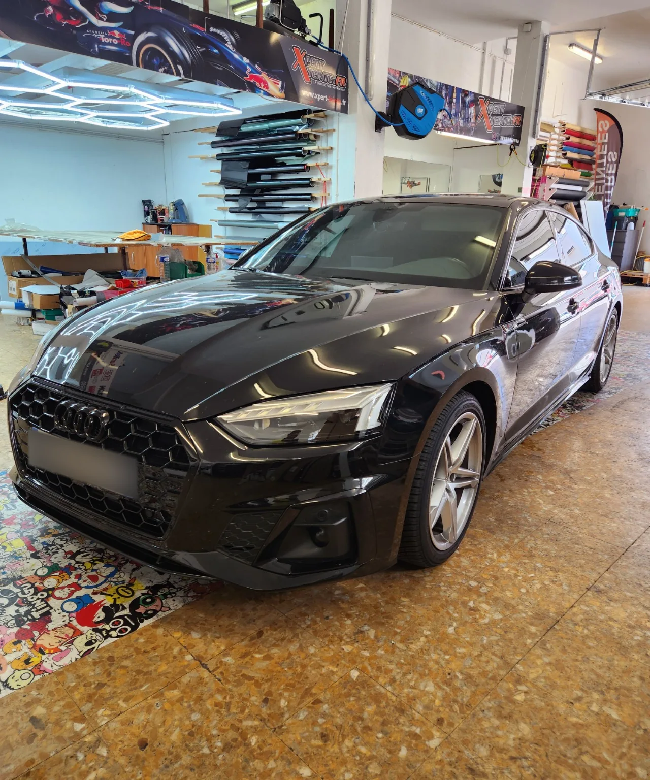 Audi A5 Sportback – vitres avant à 50 % Vue de trois-quarts avant gauche de l’Audi A5 Sportback noire avec ses vitres latérales teintées à Toulon.