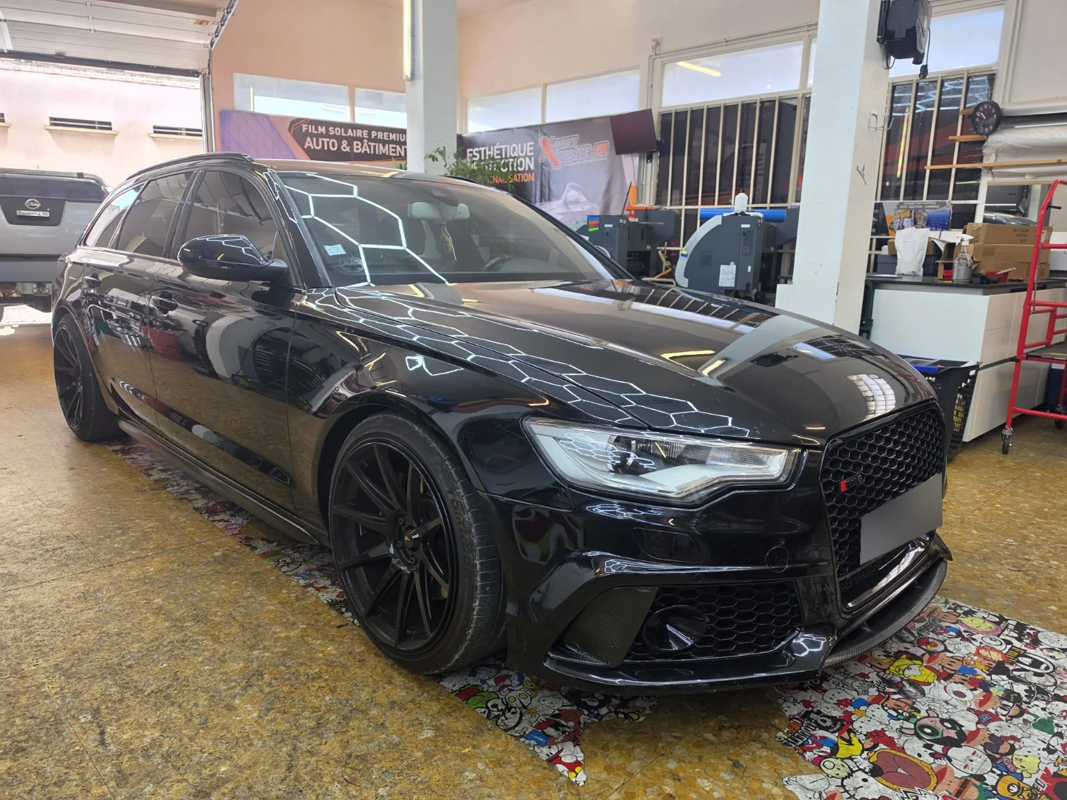 Vitres teintées Audi A6 Avant C7 à Toulon – vue avant Audi A6 Avant C7 noire vue de trois quarts avant avec ses vitres teintées dans l’atelier Xpert Teinte à Toulon.