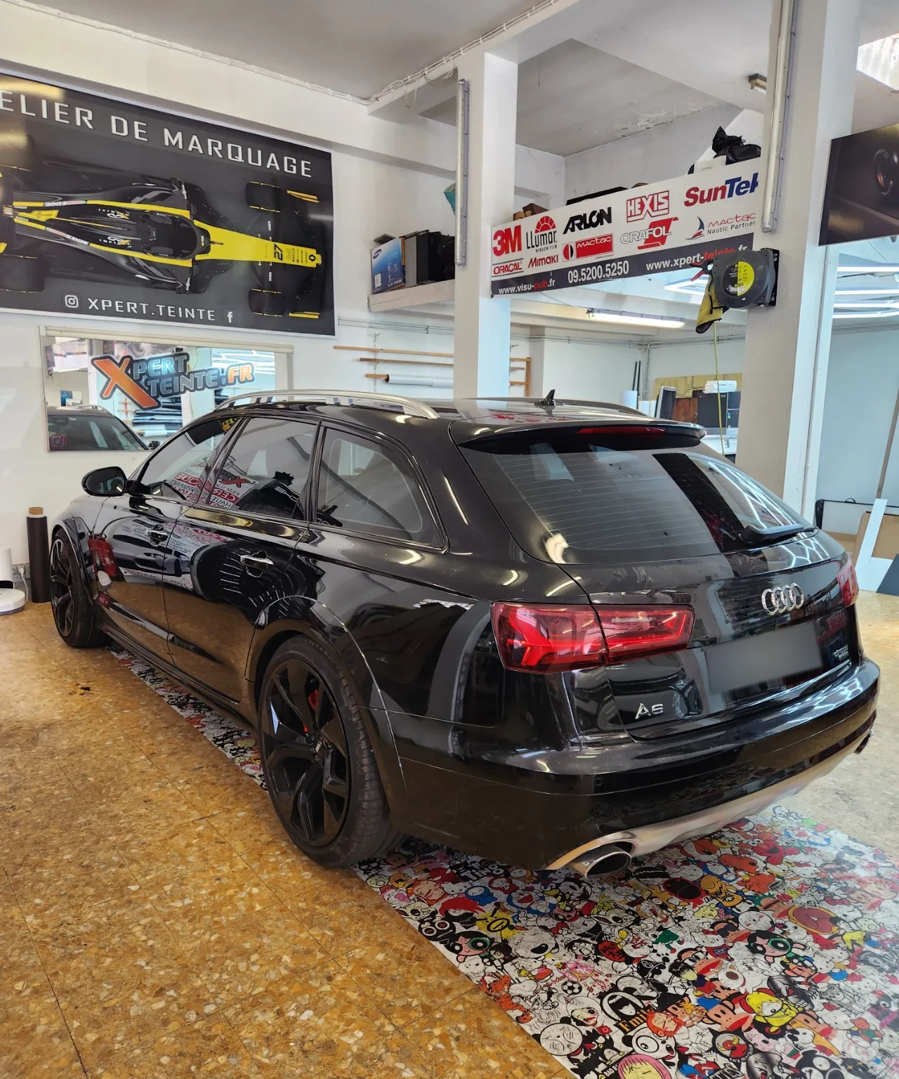 Audi A6 Avant – déchromage noir brillant à Toulon Audi A6 Avant noire vue de trois-quarts arrière, avec les contours de vitres déchromés en noir brillant et les vitres teintées.