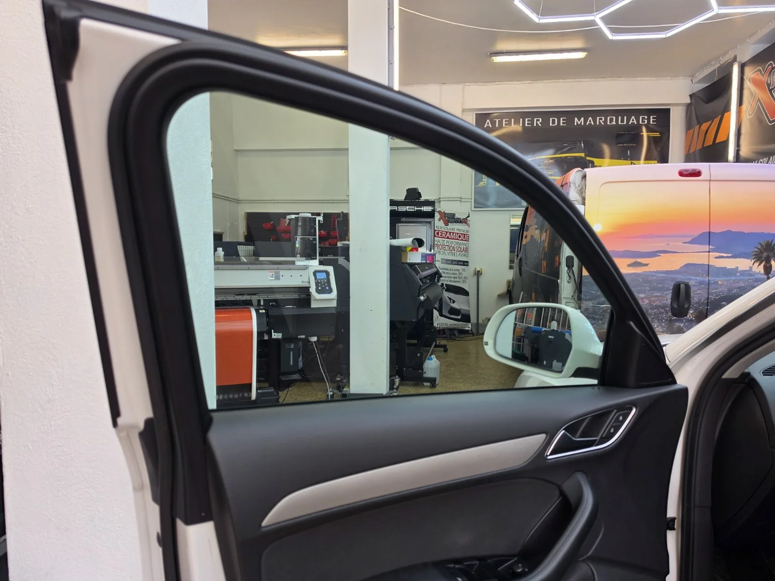 Audi Q3 – détail de la vitre avant à 30 % Vitre latérale avant de l’Audi Q3, portière ouverte, photographiée depuis l’intérieur de l’atelier.