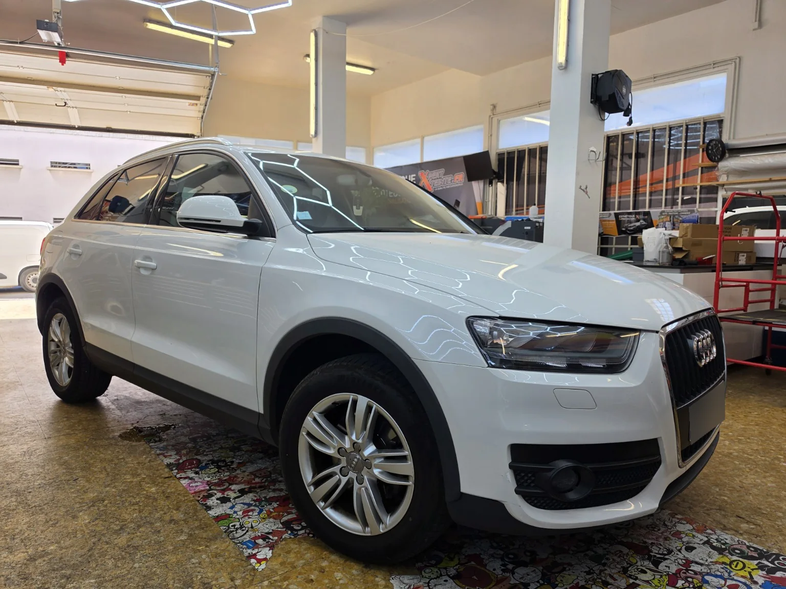 Vitres teintées Audi Q3 à Toulon – vue avant Audi Q3 blanc vu de trois quarts avant avec ses vitres teintées dans l’atelier Xpert Teinte à Toulon.