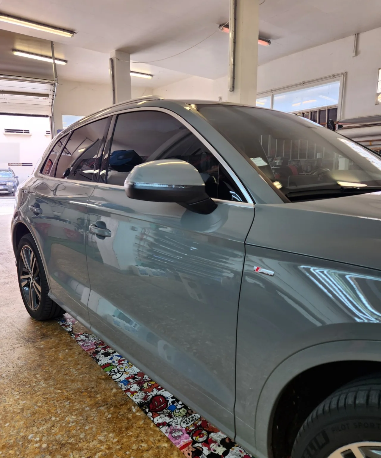 Audi Q5 gris – vitrages latéraux teintés Vue latérale avant du SUV Audi Q5 gris à l’atelier Xpert Teinte.