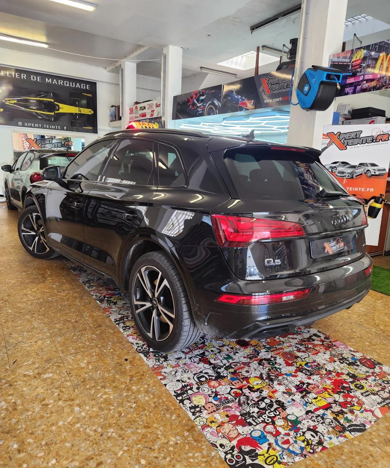 Audi Q5 taxi – déchromage piano black Audi Q5 noir utilisé comme taxi, vu de trois-quarts arrière avec les contours de vitres noirs brillants.