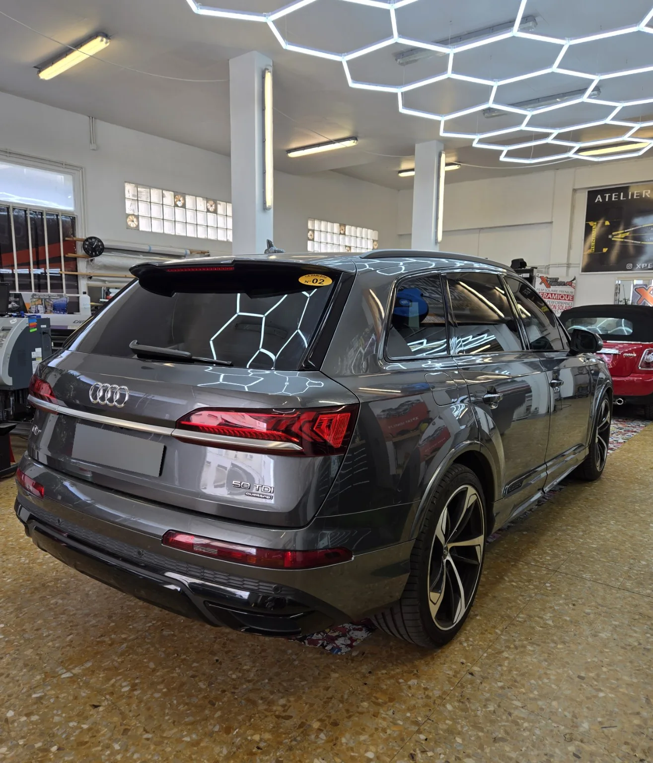 Audi Q7 – film solaire à 80 % sur le trois-quarts arrière Vue arrière droite de l’Audi Q7 gris, avec les vitres arrière, les custodes et la lunette teintées.