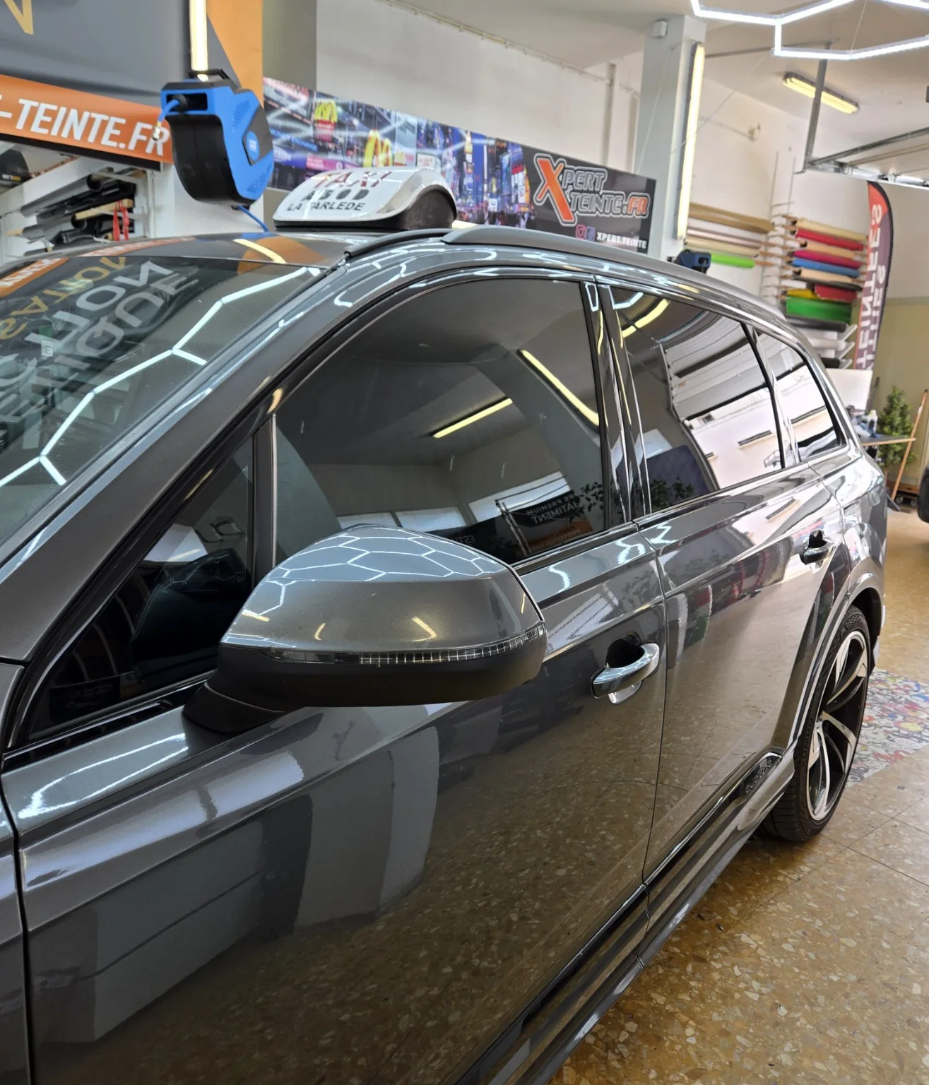 Audi Q7 – détail de la vitre avant à 50 % Vue rapprochée du côté conducteur de l’Audi Q7, montrant la vitre avant et les vitrages latéraux après la pose.