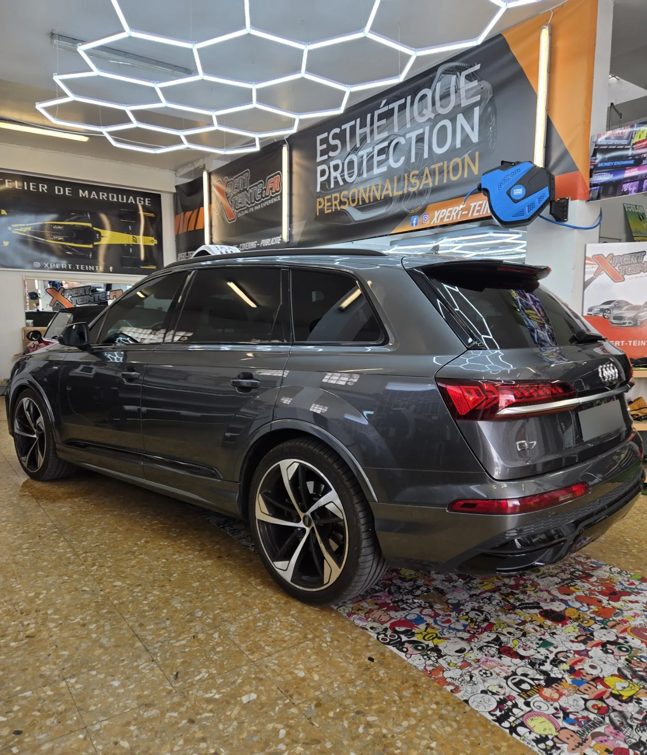 Vitres teintées Audi Q7 à Toulon – vue arrière gauche Audi Q7 gris vu de trois quarts arrière gauche après la pose de films solaires chez Xpert Teinte à Toulon.