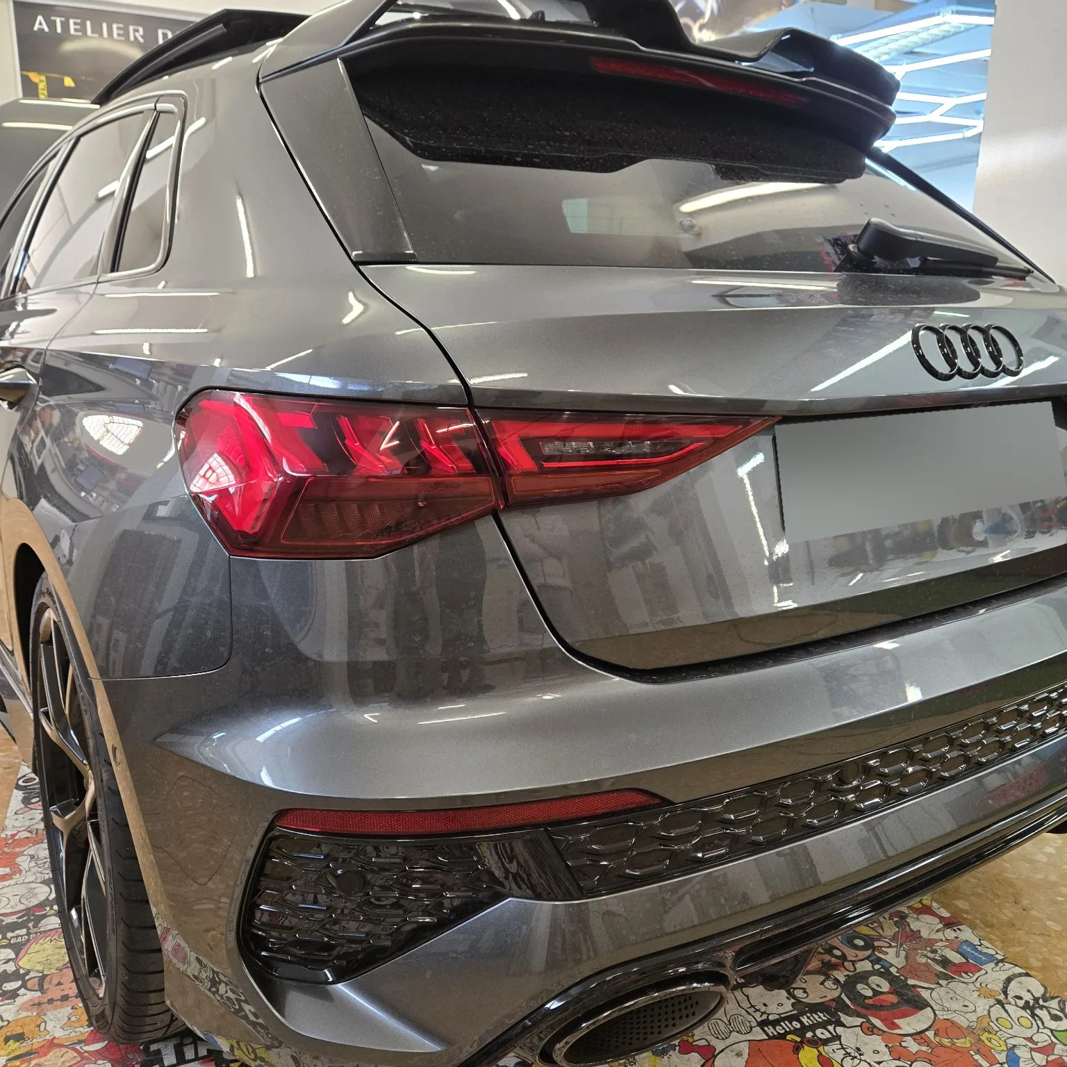 Audi RS3 – détail du feu arrière gauche Vue rapprochée du feu arrière gauche de l’Audi RS3, avec son éclairage rouge visible.
