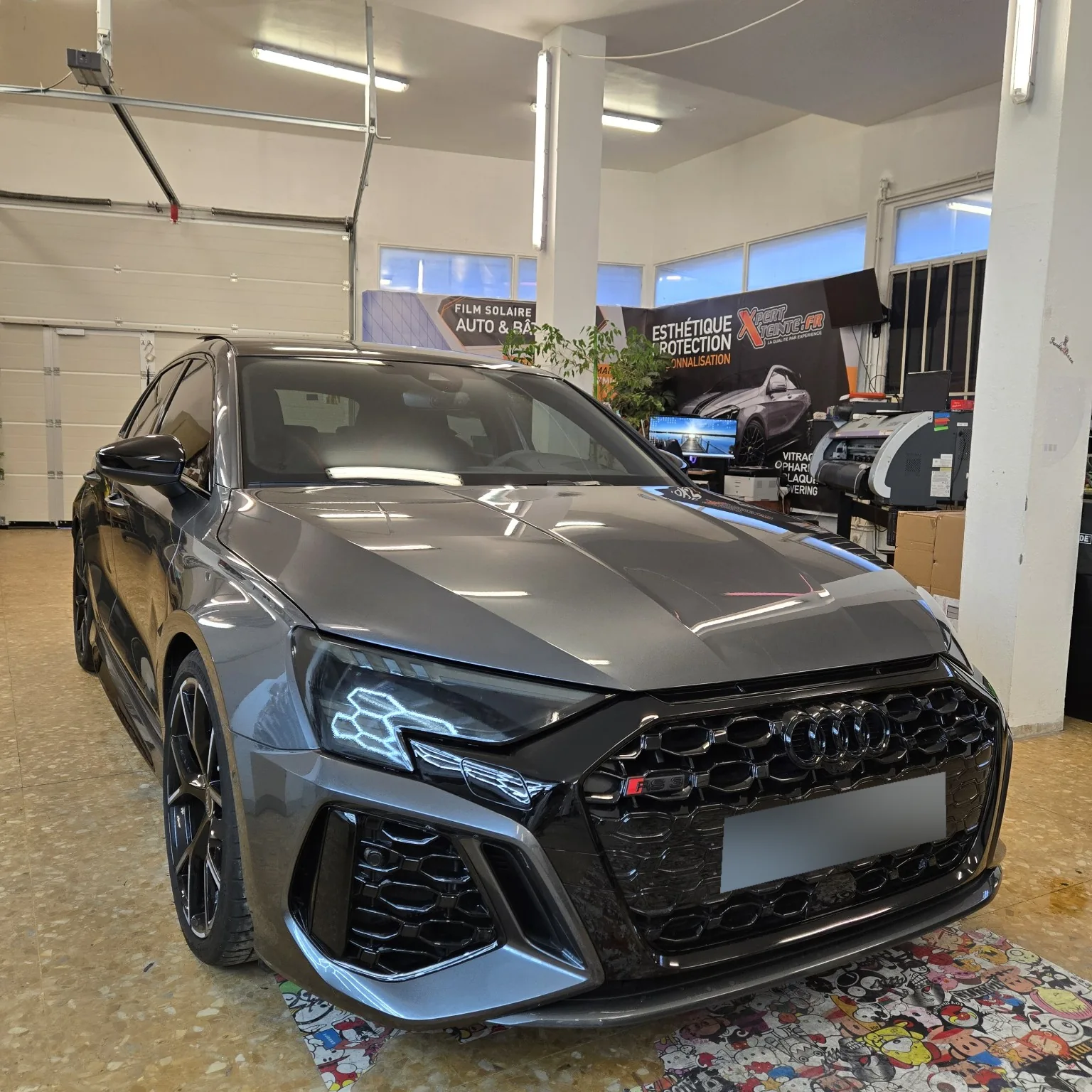 Audi RS3 – pare-brise en film thermique à 30 % Vue avant de l’Audi RS3 grise, montrant le pare-brise traité et les optiques teintées.