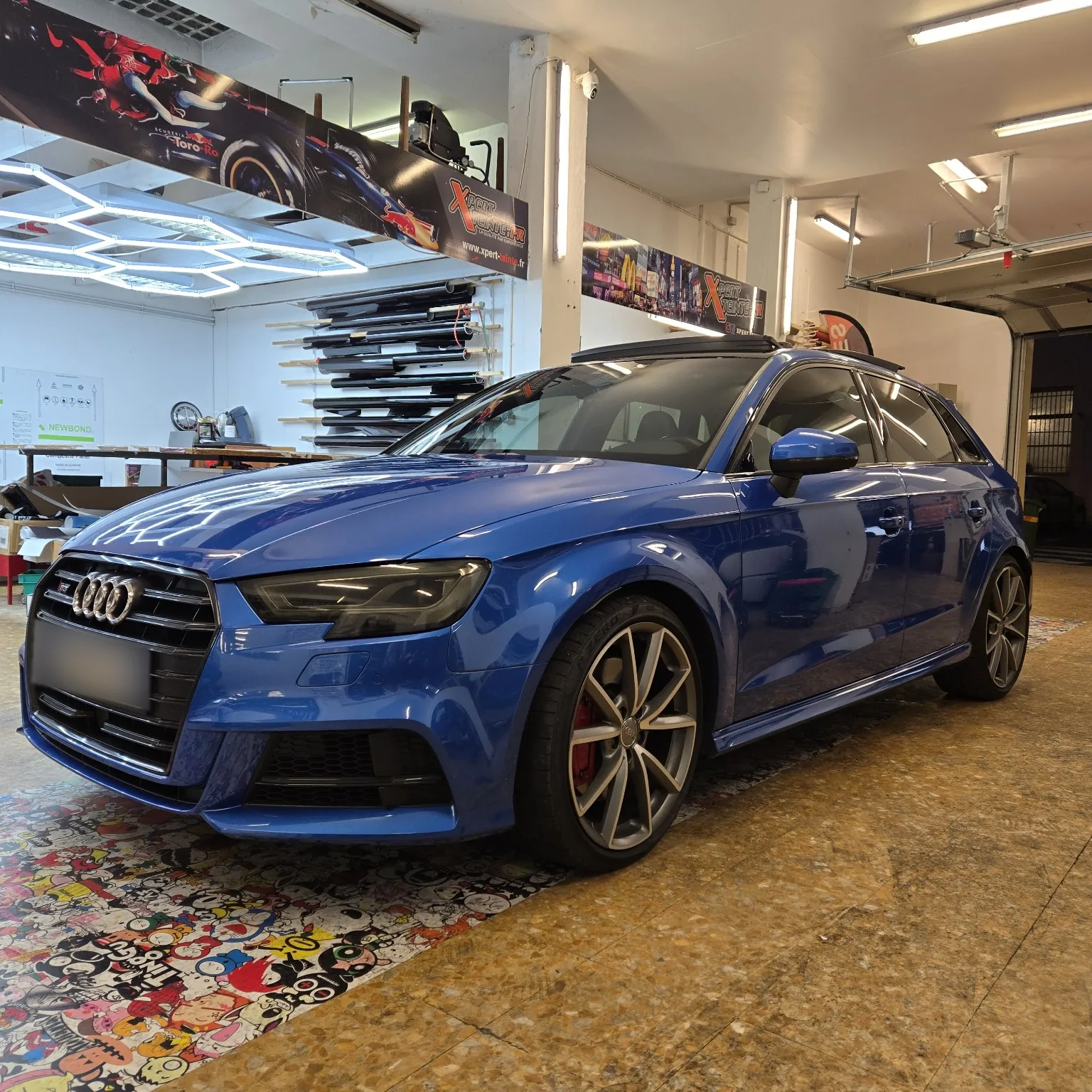 Audi S3 bleue – vue avant gauche Audi S3 Sportback bleue vue avant gauche, avec ses vitres teintées à 65 % dans l’atelier Xpert Teinte.