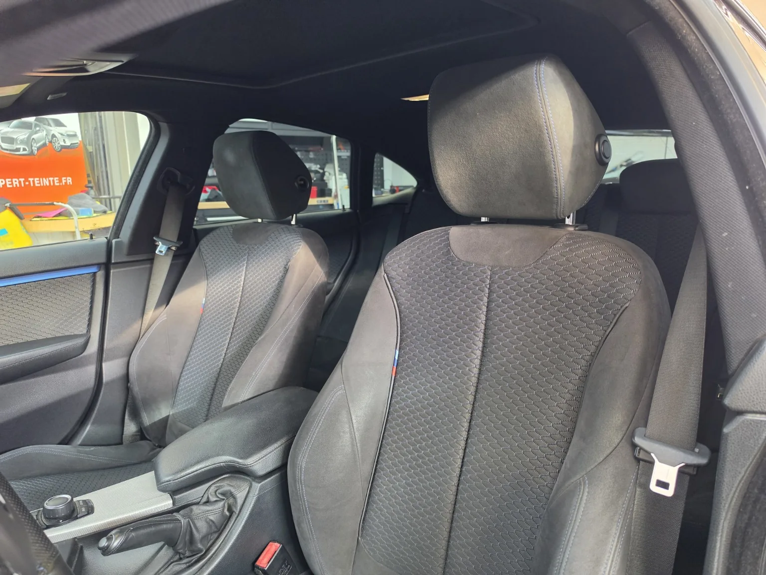 BMW Série 4 Gran Coupé – vue intérieure après la pose Habitacle de la BMW Série 4 avec ses sièges avant, ses vitres latérales et ses garnitures à liseré bleu.