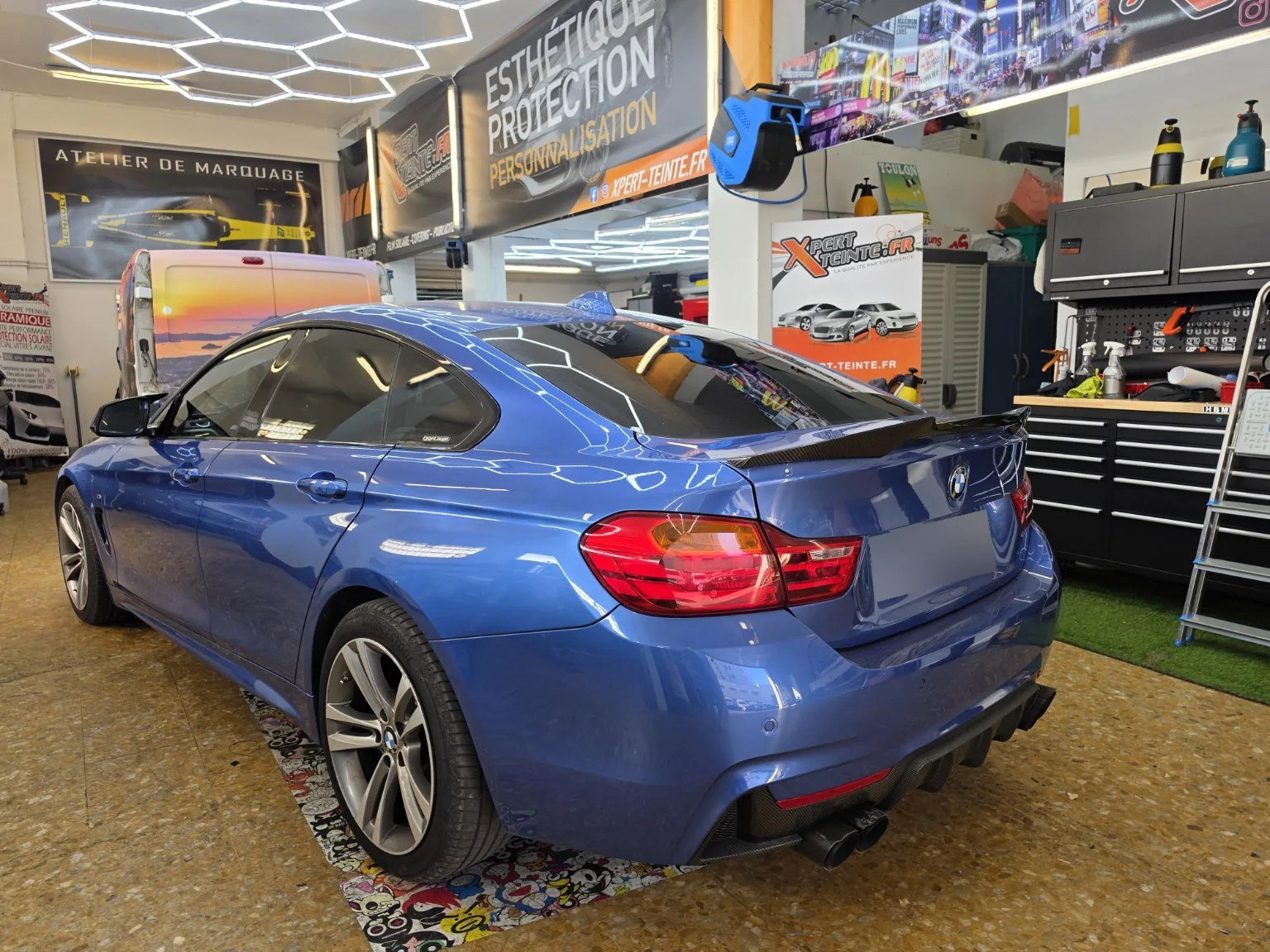 BMW Série 4 Gran Coupé F36 – vitres teintées de profil BMW Série 4 Gran Coupé F36 bleue vue de trois quarts arrière, montrant le profil et ses vitrages teintés.