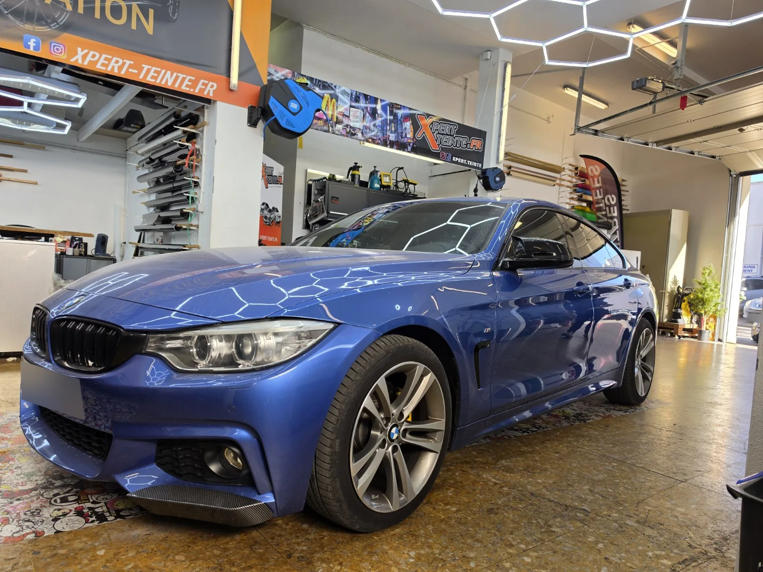 Vitres teintées BMW Série 4 Gran Coupé F36 à Toulon – vue avant BMW Série 4 Gran Coupé F36 bleue vue de trois quarts avant après la pose de films solaires chez Xpert Teinte.