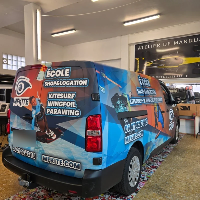 Décor bleu et orange MFKITE sur un fourgon, vue arrière trois quarts