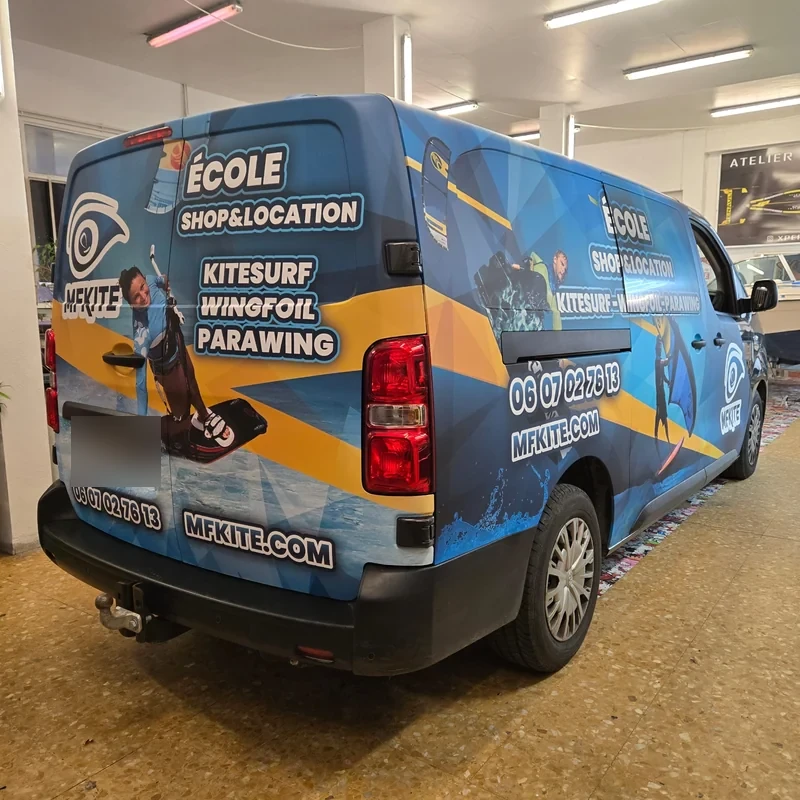 Habillage bleu et jaune MFKITE sur le flanc et l’arrière d’un fourgon