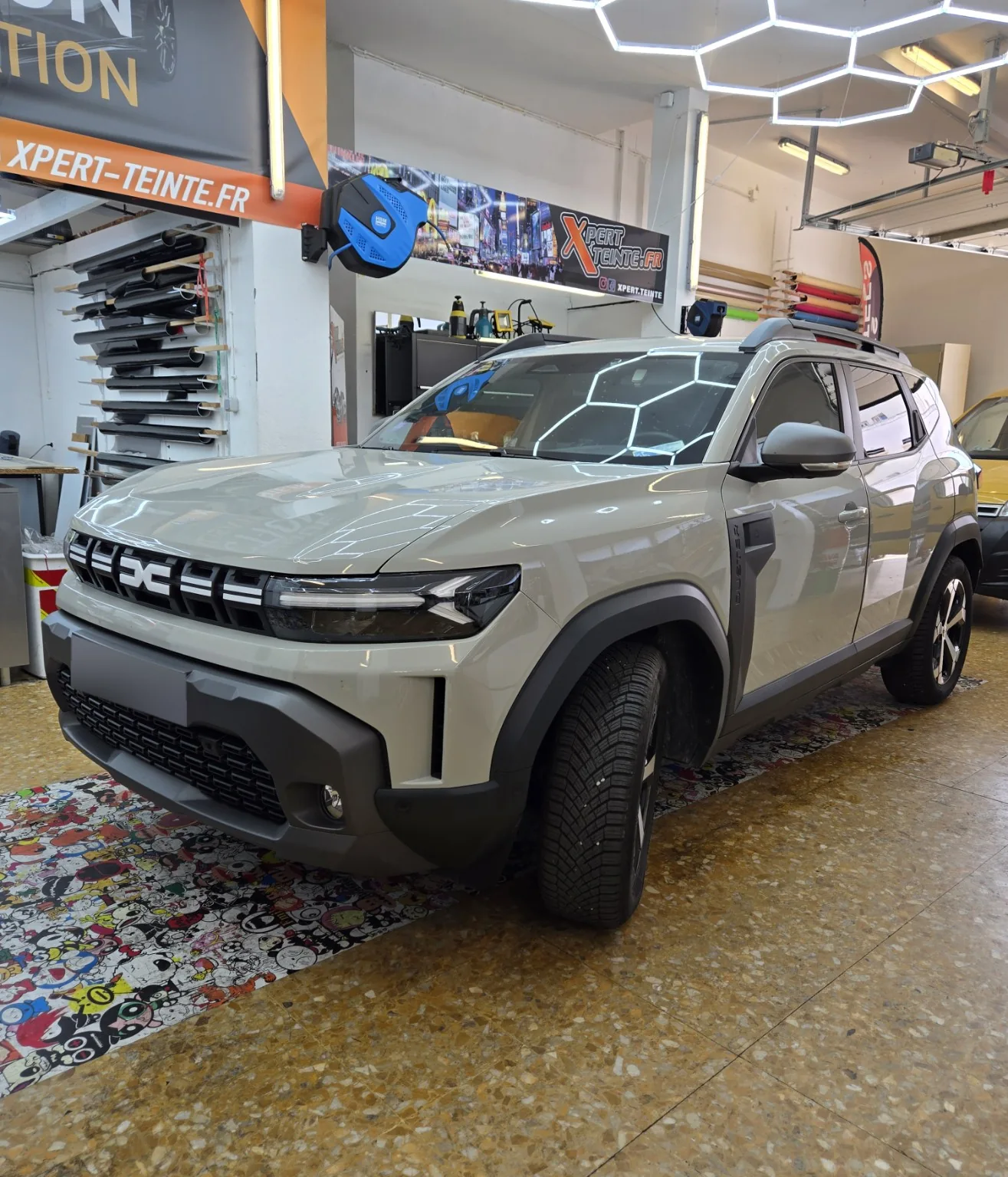 Vitres teintées Dacia Duster blanc à Toulon – vue avant Dacia Duster blanc vu de trois quarts avant, avec films teintés sur les vitres latérales dans l’atelier Xpert Teinte à Toulon.