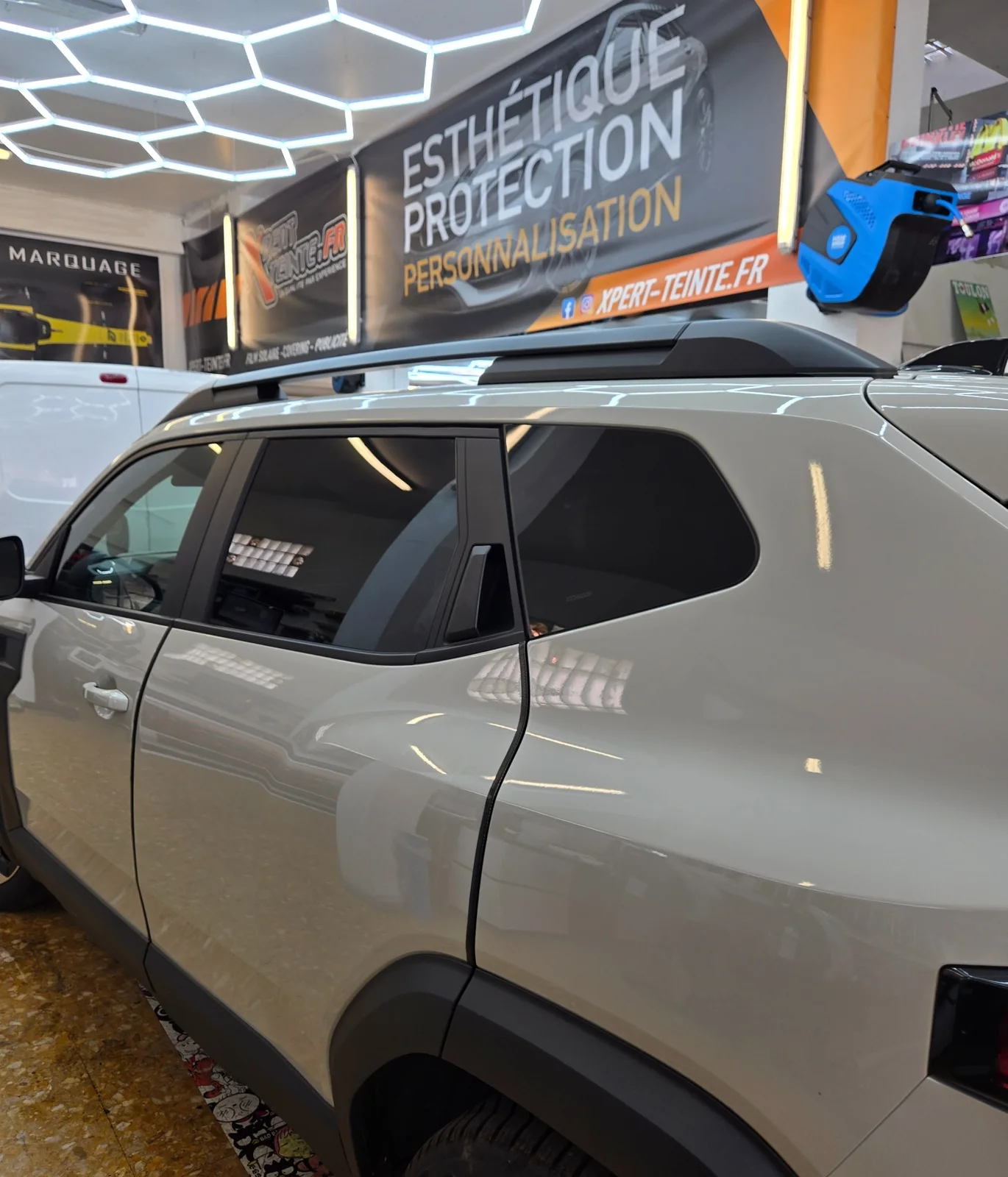 Dacia Duster – détail des vitrages latéraux Vitres latérales avant et arrière d’un Dacia Duster beige, vues de profil chez Xpert Teinte.