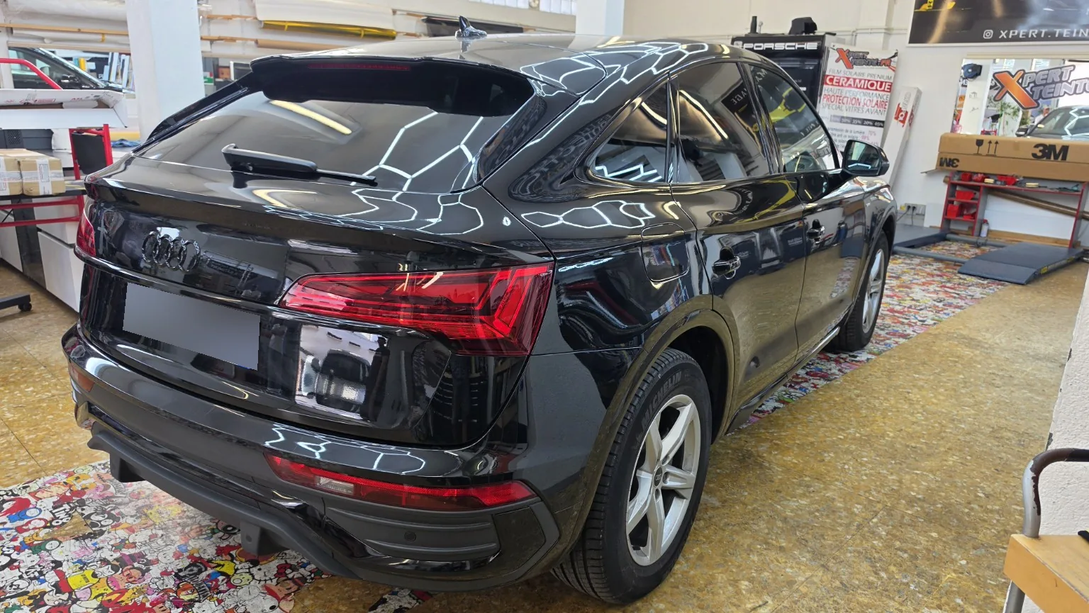 Déchromage Audi Q5 – finition arrière droite à Toulon Vue arrière droite de l’Audi Q5 après déchromage, avec les entourages de vitres et les éléments décoratifs noirs.