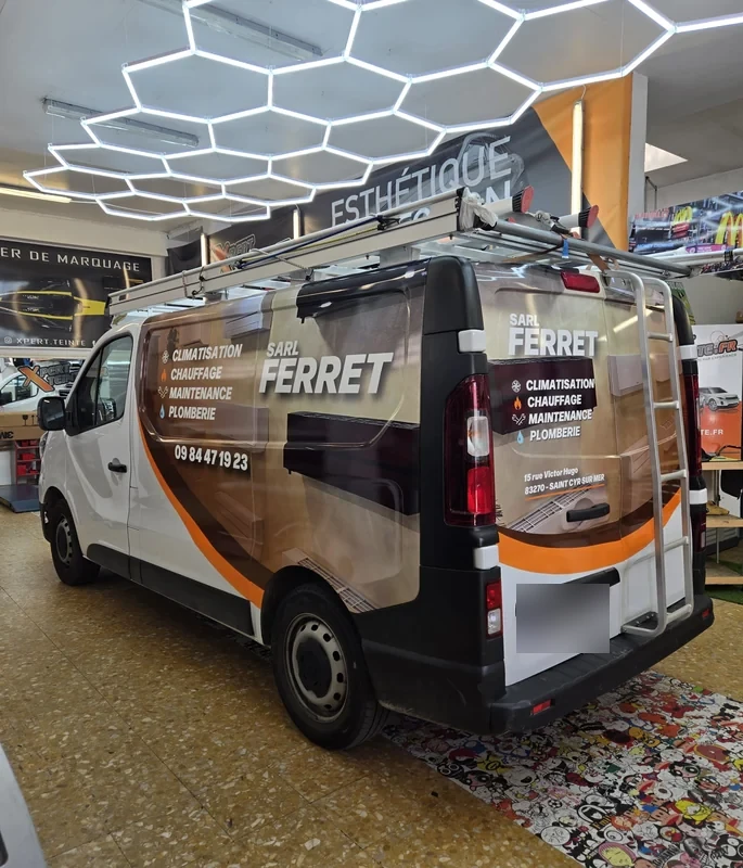 Décor publicitaire SARL FERRET sur le flanc et l’arrière d’un fourgon blanc dans l’atelier