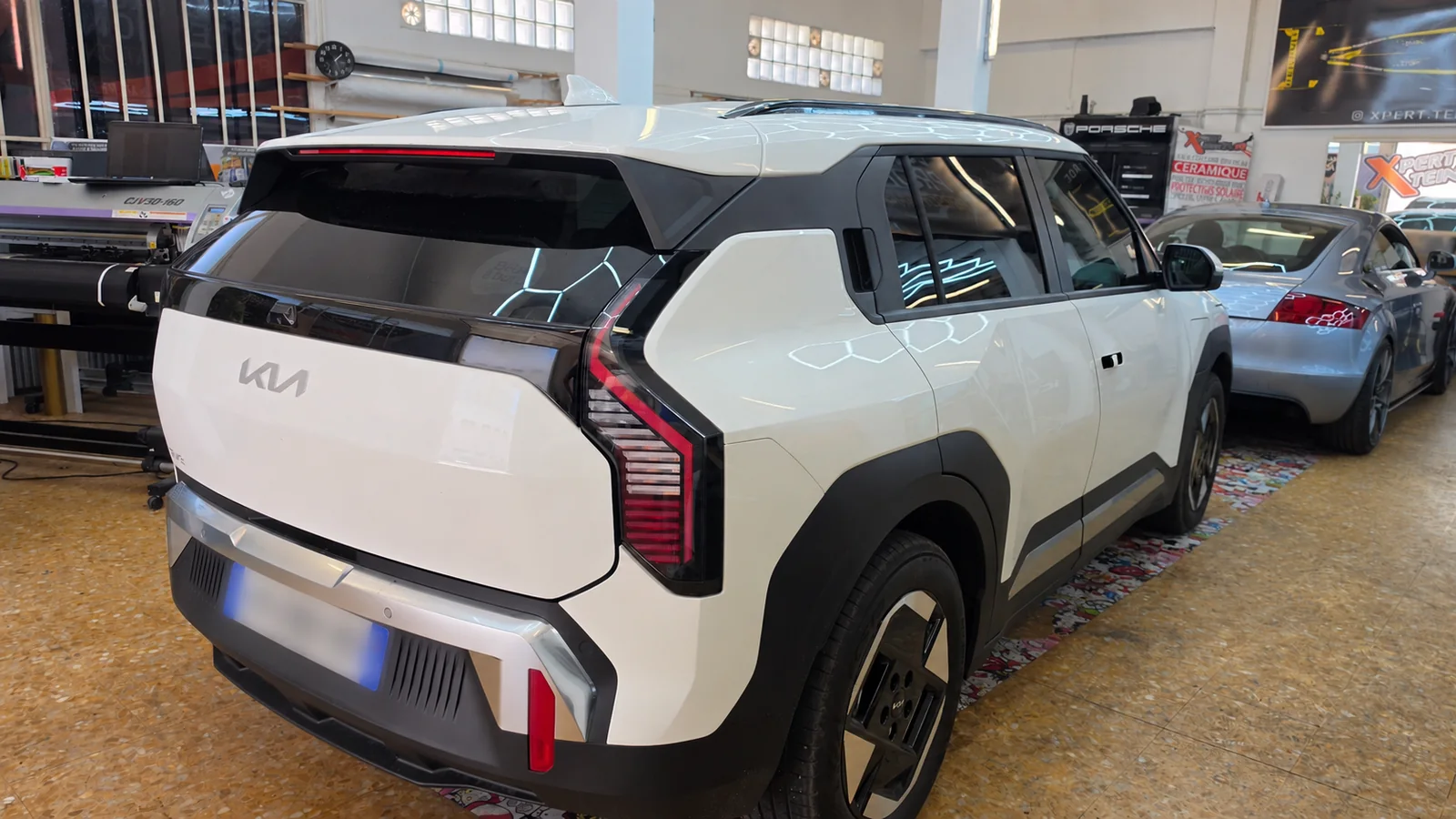 Protection solaire Kia EV3 à Toulon – vue arrière Kia EV3 blanche vue de trois quarts arrière droit, avec son hayon noir et ses vitres latérales.