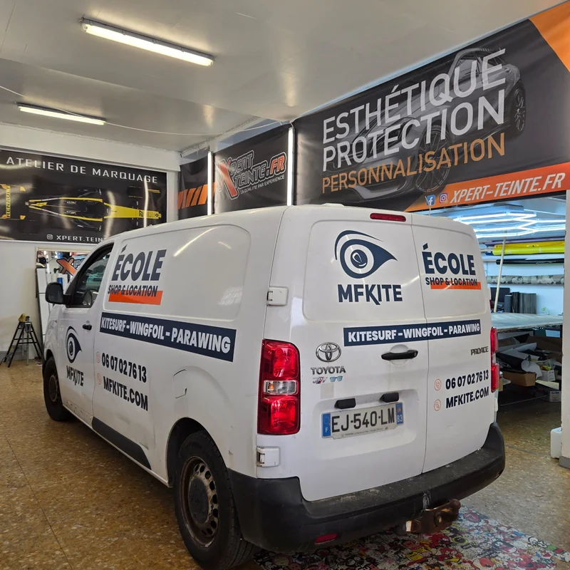 Lettrage bleu MFKITE et coordonnées sur les portes arrière d’un Toyota Proace blanc