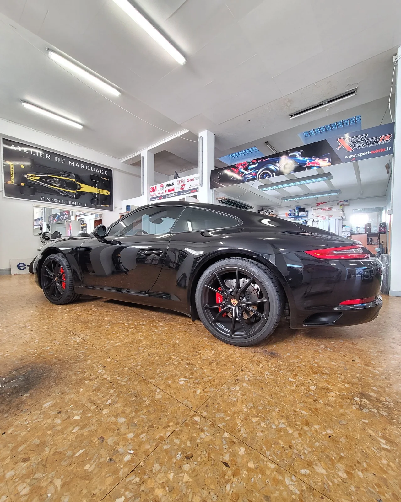 Film solaire Porsche 911 Carrera noire – vue de profil Porsche 911 Carrera noire photographiée de profil en vue basse, avec les vitres latérales et les jantes noires.