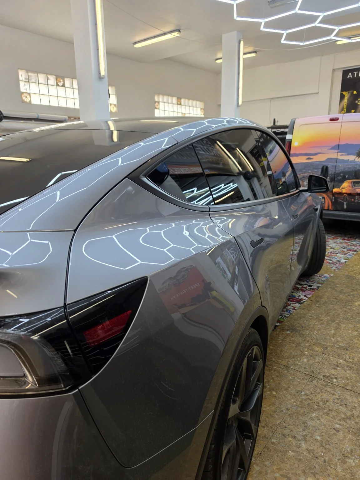 Film solaire Tesla Model Y à Toulon – vitrages arrière Vue rapprochée des vitres latérales arrière et du pavillon vitré de la Tesla Model Y grise.