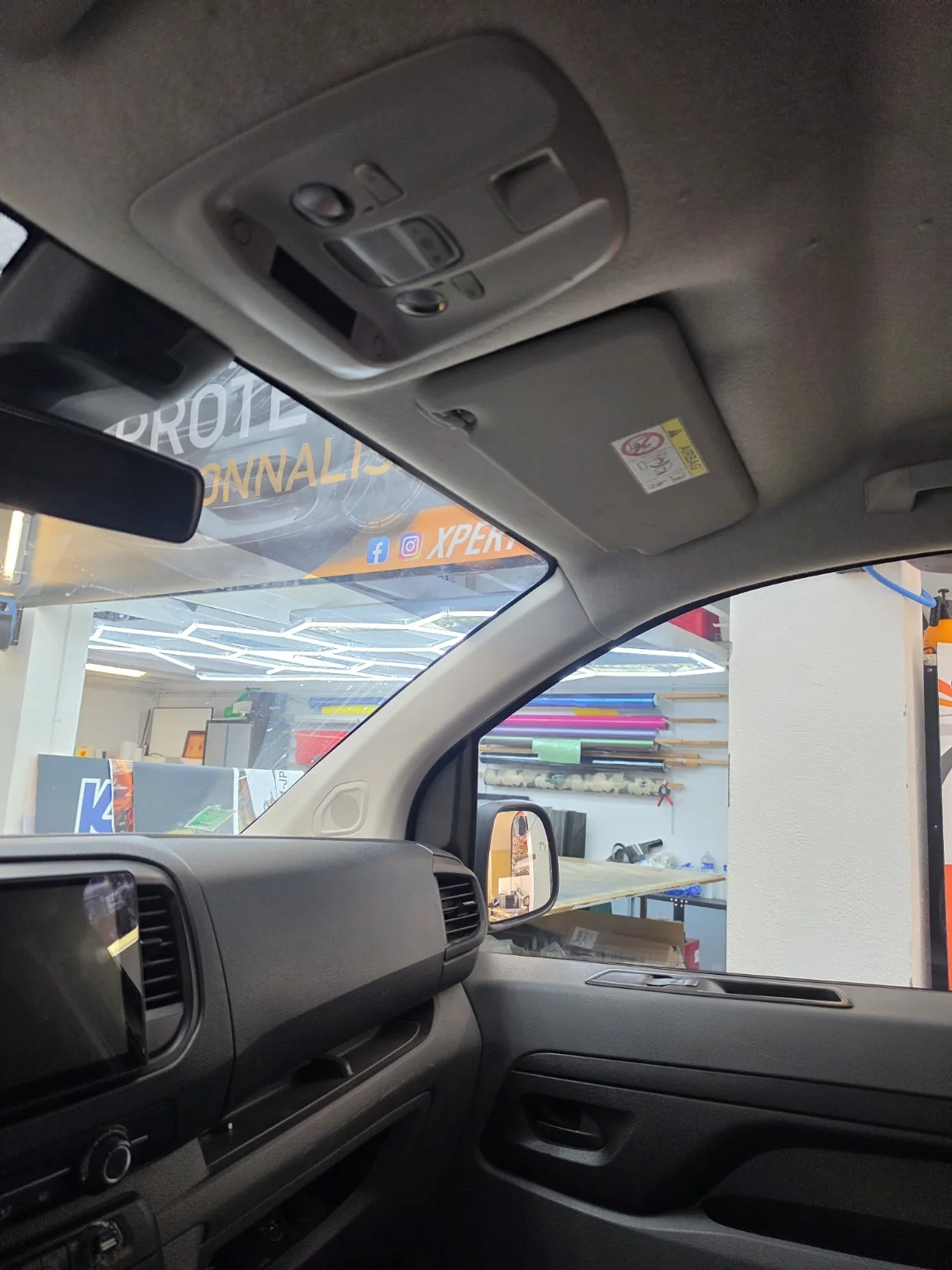 Toyota Proace – bandeau pare-soleil vu de l’intérieur Vue depuis l’habitacle du Toyota Proace vers le bandeau pare-soleil et la vitre du passager avant.