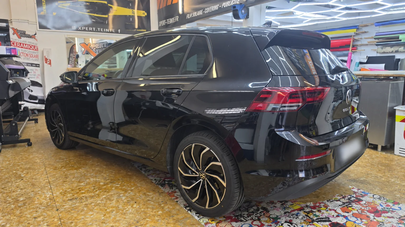 Film solaire pour Volkswagen Golf 8 à Toulon – profil arrière Profil gauche et arrière de la Golf 8 noire montrant les films solaires sur les vitrages latéraux et la lunette arrière.
