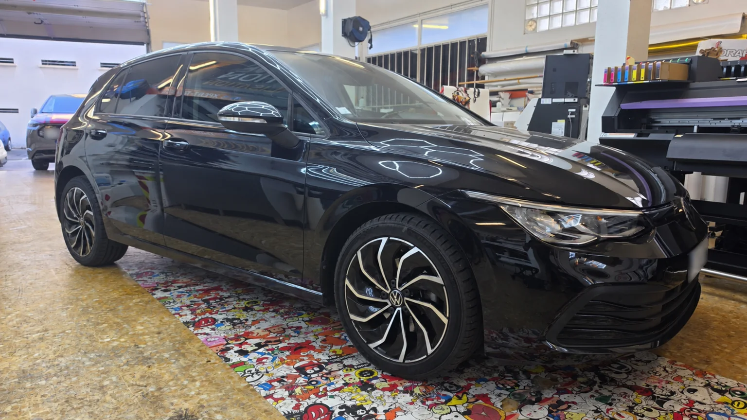 Vitres teintées Volkswagen Golf 8 à Toulon – vue avant Vitres teintées Volkswagen Golf 8 : vue avant de la voiture noire dans l’atelier Xpert Teinte à Toulon.