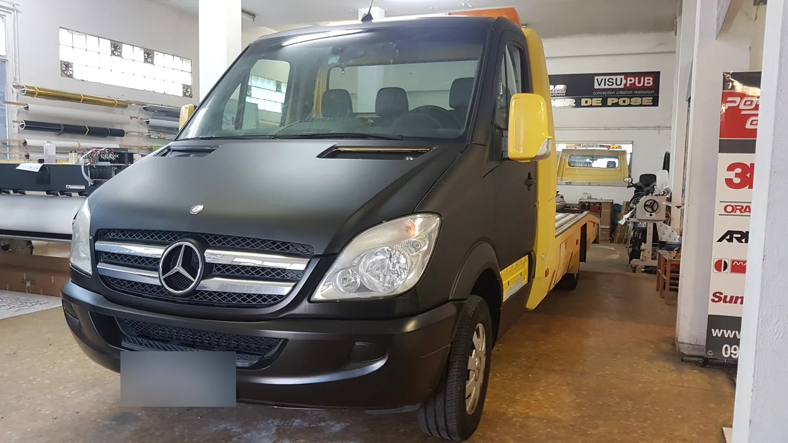 Mercedes Sprinter à cabine jaune et noire, vue avant à l’atelier. Mercedes Sprinter à cabine jaune et noire, vue avant à l’atelier — Xpert Teinte à Toulon.