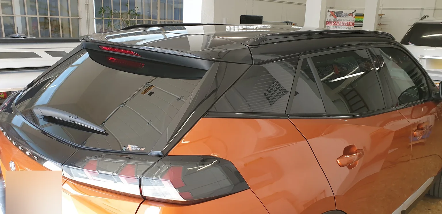 Peugeot 2008 orange : détail de la lunette, des custodes et du pavillon. Peugeot 2008 orange : détail de la lunette, des custodes et du pavillon — Xpert Teinte à Toulon.
