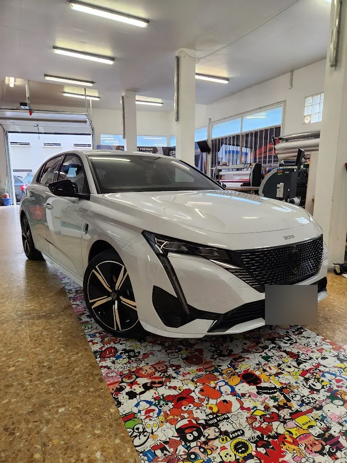 Peugeot 308 blanche : vue avant dans notre atelier. Peugeot 308 blanche : vue avant dans notre atelier — Xpert Teinte à Toulon.
