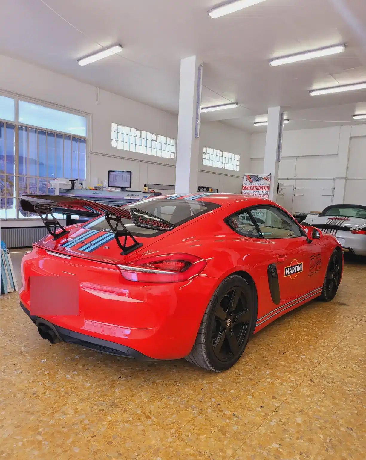 Porsche Cayman à Toulon – vue arrière du coupé Cayman 981 rouge à décoration Martini, vue arrière du coupé chez Xpert Teinte à Toulon.