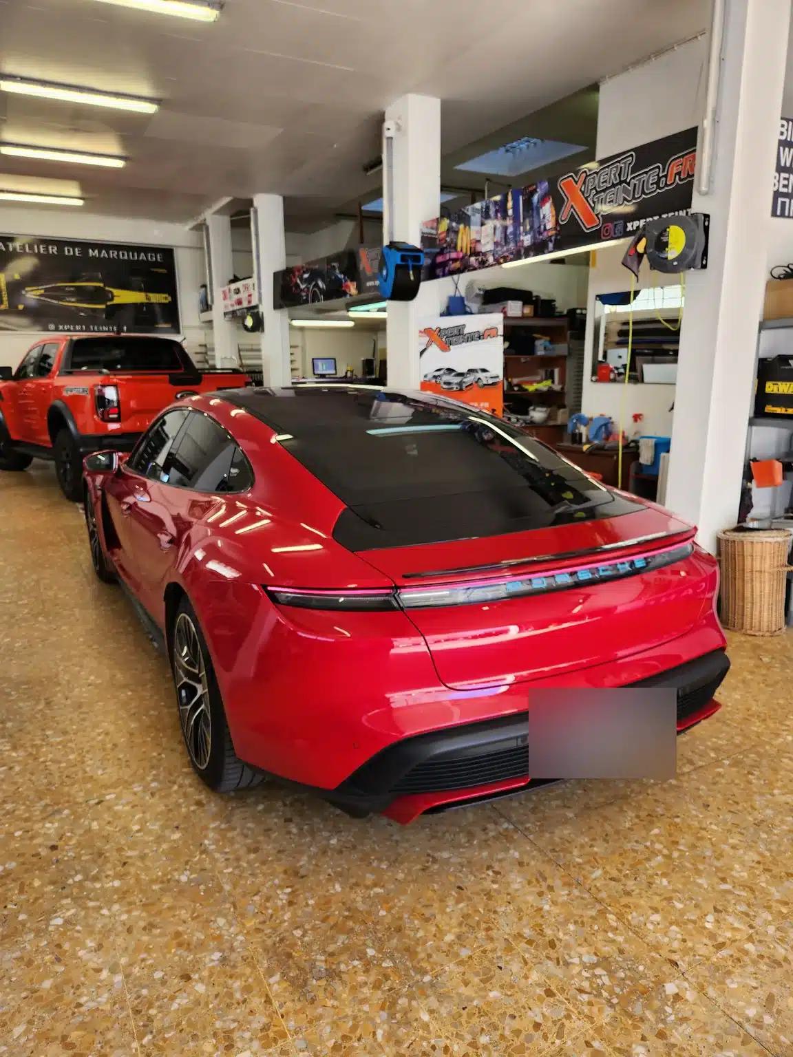 Porsche Taycan à Toulon – vue arrière de la berline et de sa lunette Taycan rouge, vue arrière de la berline et de sa lunette chez Xpert Teinte à Toulon.