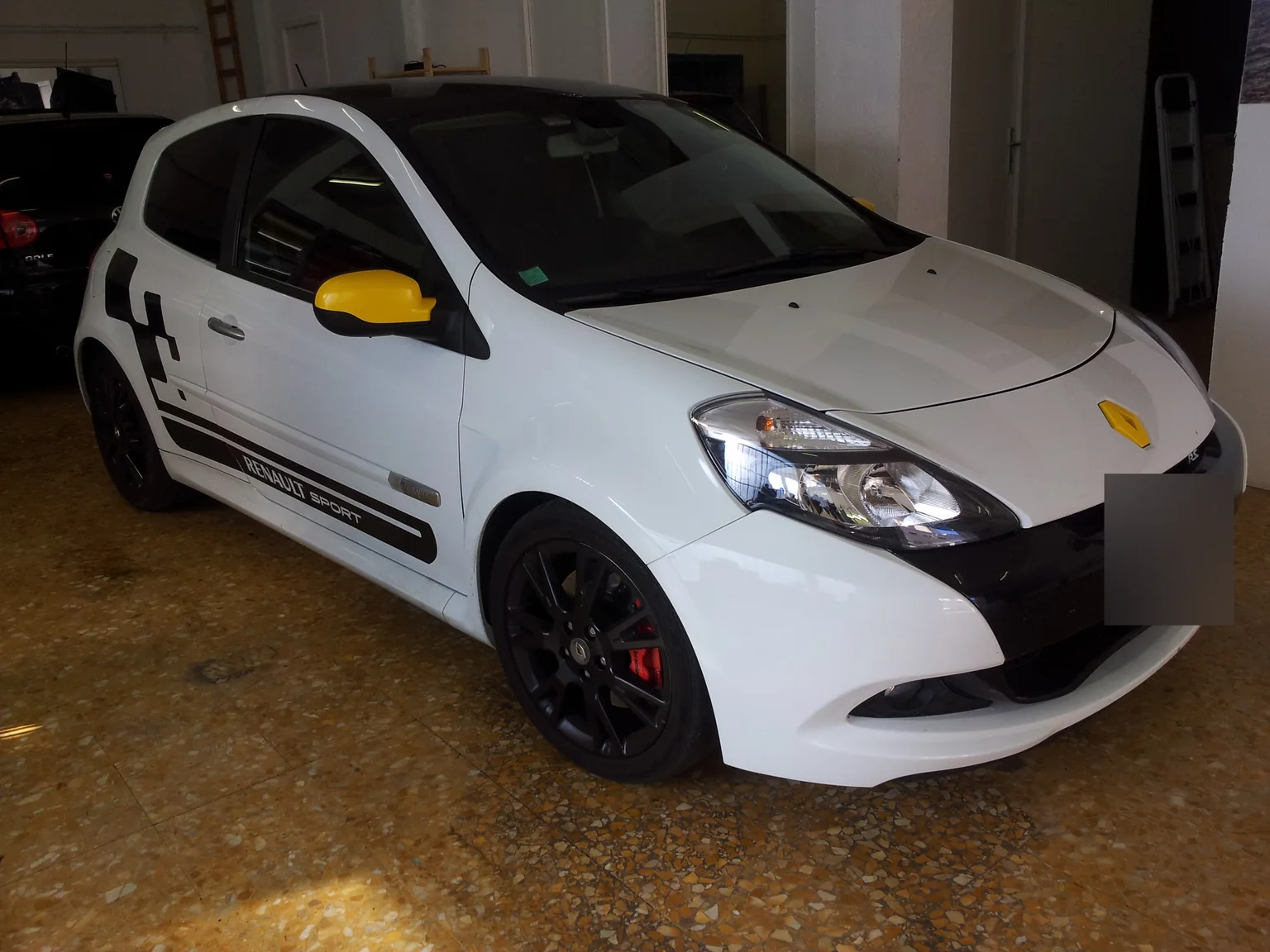 Renault Clio 3 blanche personnalisée : vue avant et vitrages latéraux. Renault Clio 3 blanche personnalisée : vue avant et vitrages latéraux — Xpert Teinte à Toulon.