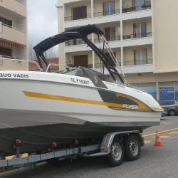 Bénéteau Flyer blanc avec un décor de coque noir et jaune, vu de trois quarts avant.